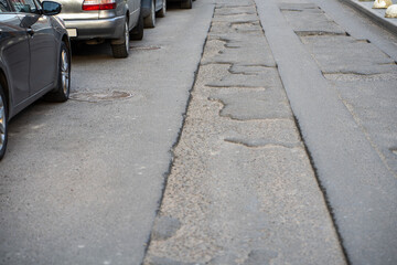 Broken asphalt road in city and untimely repair in parking lot. Pothole asphalt road repairs....