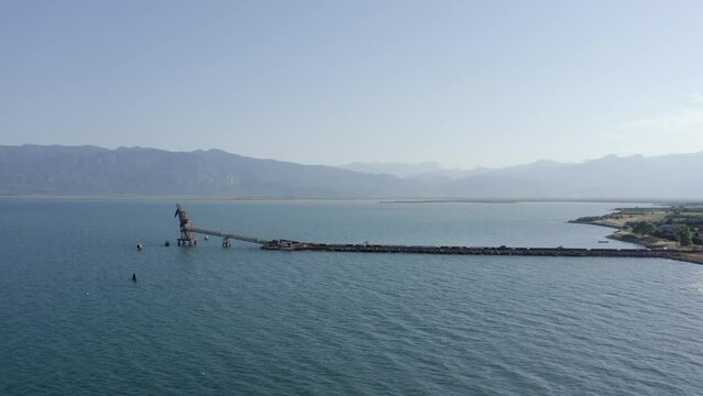 Long conveyor pier brings aggregate ore to mooring for sea shipping
