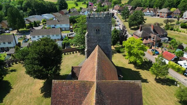 A slow push-in shot of a union flag flying from the tower of St Mary's church in Chartham.
