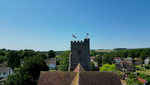 A slow ascending boom-shot of St Mary's church, with Chartham in the background, and a union flag flying from the tower.