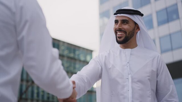Handsome businessman with the traditional emirates white outfit working outdoor in Dubai city. Concept about middle eastern cultures and business