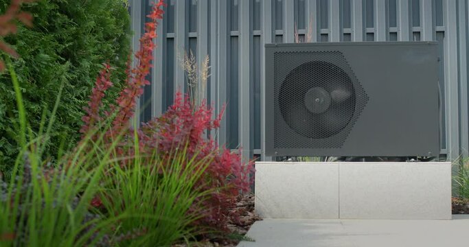 The heat pump for heating the pool is mounted on site. Ornamental plants nearby. Energy Saving Technologies. 4k video