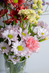 pink spring flowers in glass jug on white background