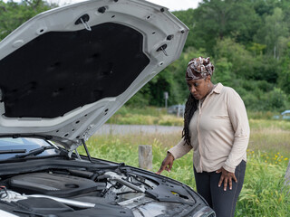 Fototapeta na wymiar Woman standing over broken-down car