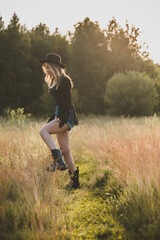 Naklejka na ściany i meble Sexy Girl in American country style, suede leather boho jacket and shorts, cowgirl style at nature