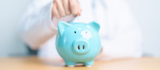 Doctor holding piggy bank and putting coin. and Healthcare cost, Money Saving, Health Insurance,...