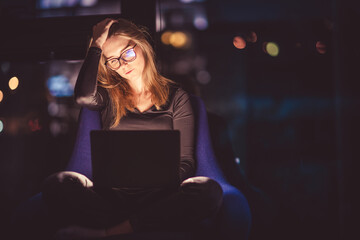 Woman boss working on laptop at night.