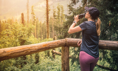 Young girl drinking water during a stop on a trip in the mountains.