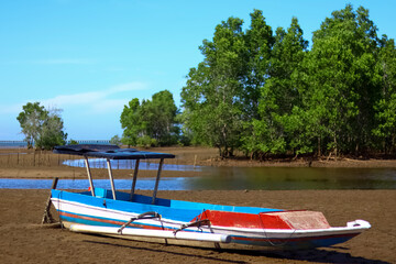 Naklejka na ściany i meble Fishing boat leaning on the coast of Kenyamukan Beach, Sangatta, East Kalimantan, Indonesia in the morning.