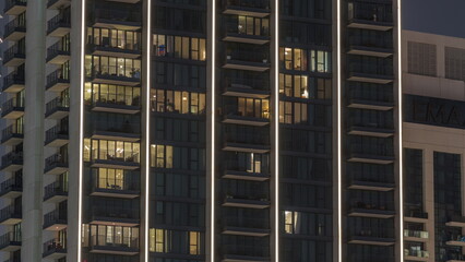 Tall blocks of flats with glowing windows located in residential district of city aerial timelapse.