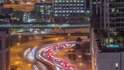 Fototapeta premium Top aerial view of busy road intersection and traffic junctions in Dubai city night timelapse.