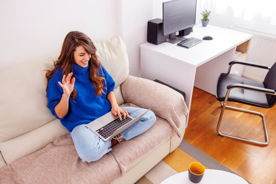 Woman having video call using laptop computer while working from home