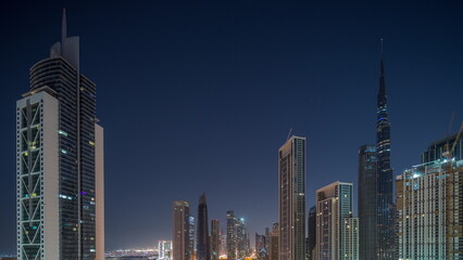 Aerial sunrise view of Dubai Downtown skyline with many towers night to day timelapse.