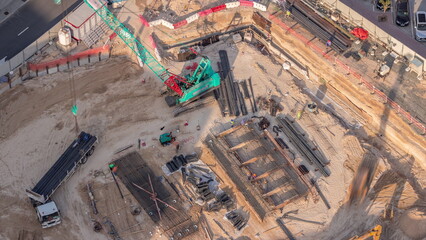 Fototapeta premium Aerial view construction site with a foundation pit of new skyscraper timelapse.