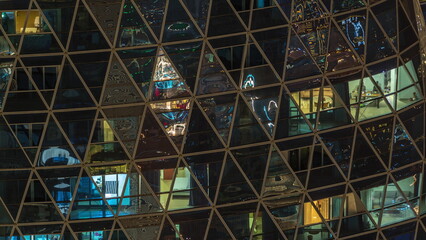 Frontal view of night facade of apartment building with a lot of windows with light timelapse.
