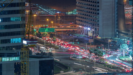 Fototapeta na wymiar Skyscrapers and traffic on crossroad near Business Bay Metro Station alongside Sheikh Zayed Road in Dubai night timelapse.