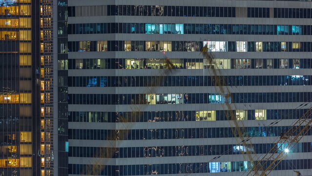 Office and residential buildings windows illuminated at night timelapse