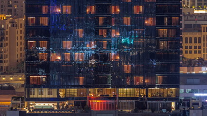 Office and residential buildings windows illuminated at night timelapse