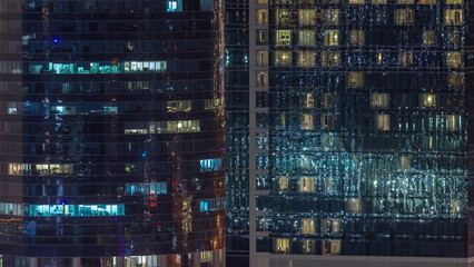 Fototapeta na wymiar Office and residential buildings windows illuminated at night timelapse