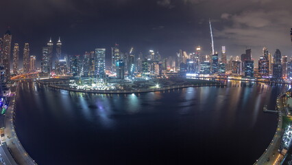 Fototapeta premium Aerial skyline panorama of Dubai Business Bay and Downtown with the various skyscrapers and towers night timelapse