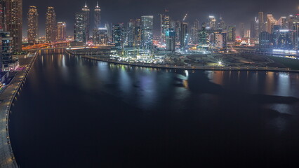 Fototapeta na wymiar Cityscape with skyscrapers of Dubai Business Bay and water canal aerial night timelapse.
