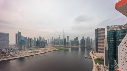 Aerial skyline of Dubai Business Bay and Downtown with the various skyscrapers and towers day to night timelapse