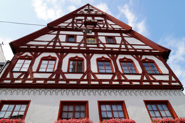 a beautiful ancient Bavarian town of Noerdlingen with its half-timbered houses with red geraniums on a summer day (Bavaria, Germany)	