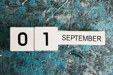 Wooden calendar on a dark background. The date is September 1, the Day of Knowledge.