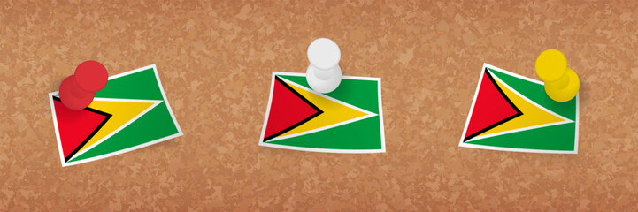 Guyana flag pinned in cork board, three versions of Guyana flag.