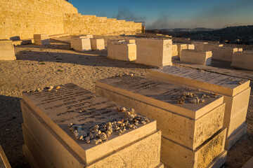 Graves of the Mount of Olives Jewish Cemetery, with the smoke on Gaza Strip in the background, in...