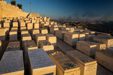 The Mount of Olives Jewish Cemetery, with the smoke on Gaza Strip in the background, in Jerusalem 