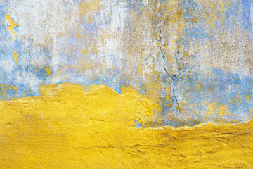Cracked stucco blue yellow background, weathered faded wall texture