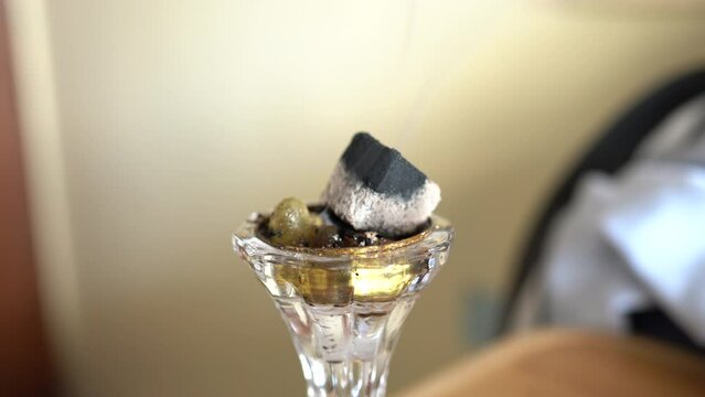 Small metal decorative Arabian Bakhoor incense burner emitting white smoke - aloeswood, essential oil and burning incense chips