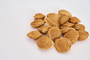 Apricot pits on a white background. Side view. Vitamin B 17. Healthy food background. There is space for text