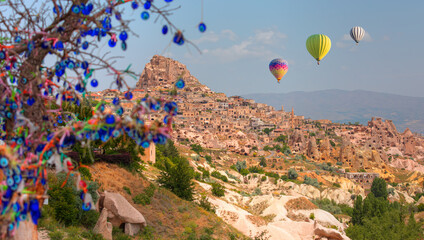 Hot air balloon flying over spectacular Cappadocia - Carved houses in rock and an Nazar (evil eye)...
