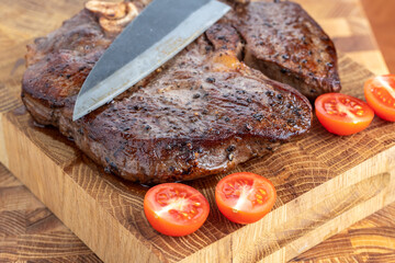 A steak on a cutting board with herbs and spices.Grilled beef tenderloin steak on a wooden board...