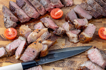 A steak on a cutting board with herbs and spices.Grilled beef tenderloin steak on a wooden board with grilled vegetables. Filet Mignon recipe concept, selective focus