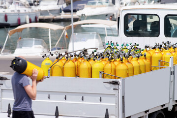 scuba tanks of diving center with air nitrox or trimix in marina port  for courses or dive trips