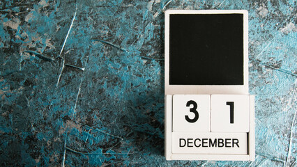 Wooden calendar on a dark background. December 31, New Year.