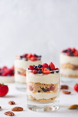 Vegan dessert in a glasses with berries, whipped cream and biscuit. Healthy food, sugar, gluten and lactose free.