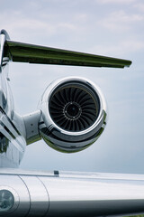 Close-up of jet engine turbine on business aircraft against clear blue sky
