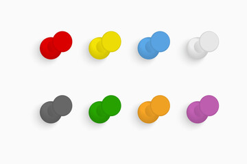 Colorful push pins set on light background.