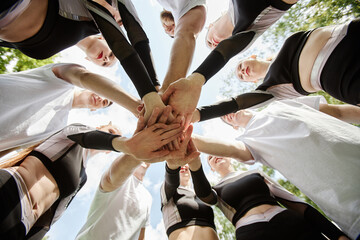 Low angle view of cheerleader team holding hands and supporting each other before competition