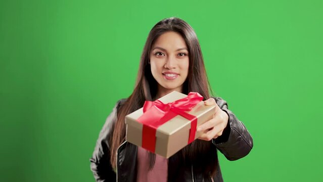 Asian Girl with a confident smile in a studio with a present box - extreme slow motion shot