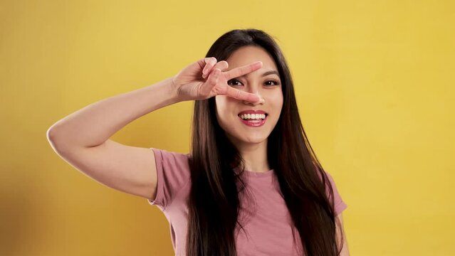 Asian Girl with a confident smile in a studio fooling around - extreme slow motion shot