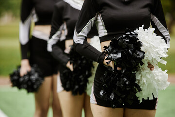 Close-up of group of cheerleading women dancing with pompom outdoors