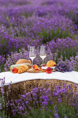 A summer picnic in a lavender field with croissants, peaches, salami, cheese and a bottle of wine...