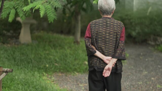 old elderly elder senior woman walking in japanese garden