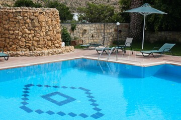 Generic vacation resort swimming pool. Sunbeds in Crete, Greece.