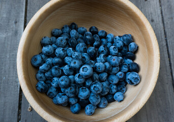 Photo top view of a wooden bowl with a ripe, large, juicy and bright pigeon. Beautiful selected berries.